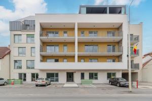 ein Mehrfamilienhaus mit auf einem Parkplatz geparkten Autos in der Unterkunft Up Above at Waterview Collection in Oradea