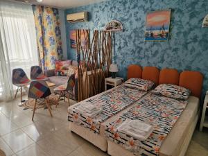 a bedroom with a bed and a table and chairs at Студио в Затворен Комплекс Blue in Sozopol