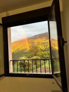 ein Fenster mit Blick auf einen Regenbogen am Himmel in der Unterkunft Entre gigantes, La Alhambra y Sierra Nevada in Güéjar-Sierra + 38 Fotos