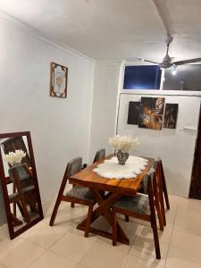 a dining room with a wooden table and chairs at AnnexSarova Homestay in Migombani +10 photos