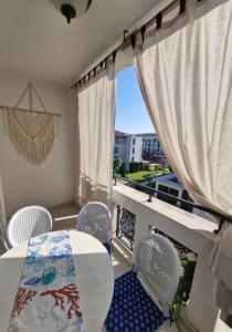 a balcony with a table and chairs and a window at Студио в Затворен Комплекс Blue in Sozopol