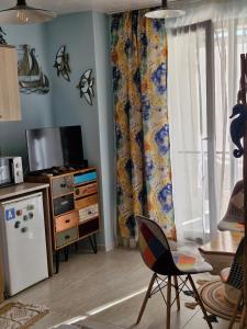 a living room with a refrigerator and a tv at Студио в Затворен Комплекс Blue in Sozopol