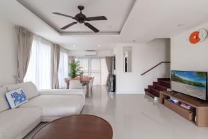 a living room with a couch and a ceiling fan at Friendly Townhouse Laguna Park in Thalang