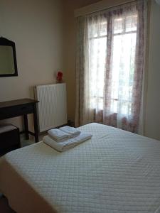 a bedroom with a white bed and a window at Kaos House in Nydri