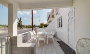 アヤナパにあるDeluxe Apt - 500m Nissi Beach!のバルコニーにテーブルと椅子が置かれたパティオ