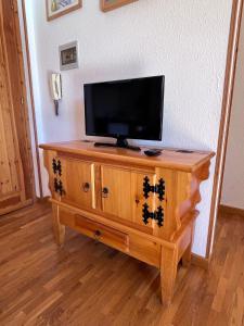 TV en la parte superior de un armario de madera en Appartamento Salice 2000 - G, en Sauze d'Oulx