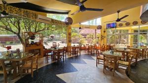 a restaurant with wooden tables and chairs and windows at Habitaciones frente al mar in Carretal