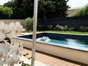 a swimming pool in the middle of a backyard at Maison 120m, jardin, parking, piscine in Sainte-Cécile-les-Vignes