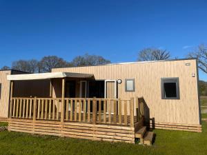 a modular home with a porch in front of it at Camping VVF Pontivy in Pontivy