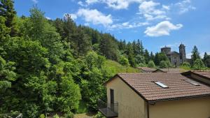a house on a hill with trees and a building at La Casa del Pittore in Pietramala