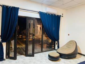 a room with blue curtains and a chair and a window at Amor Luse in Arugam Bay