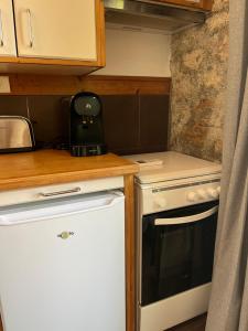 Il comprend une petite cuisine équipée d'une cuisinière et d'un réfrigérateur. dans l'établissement Maisonnette face au Garlaban, à Roquevaire 12 autres photos