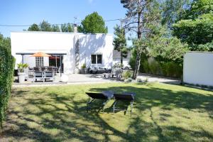 a backyard with two chairs and a table in the grass at Maison de vacances à Quend-plage in Quend-Plage