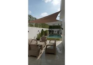 a patio with chairs and a swimming pool at Villa luxueuse en famille Hammamet in Hammamet Sud