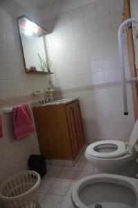 une salle de bain avec toilettes, lavabo et miroir dans l'établissement Depto con balcón, pleno centro, à San Nicolás de los Arroyos