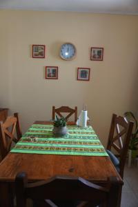 une table à manger avec une horloge sur le mur dans l'établissement Depto con balcón, pleno centro, à San Nicolás de los Arroyos