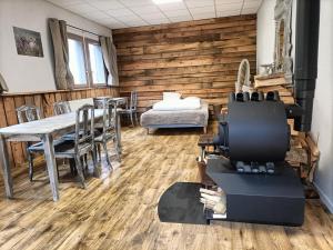 Saint-FrontにあるGîte La Draï L'âme du trappeur au pied d'un volcanのテーブルと椅子、木製の壁が備わる客室です。