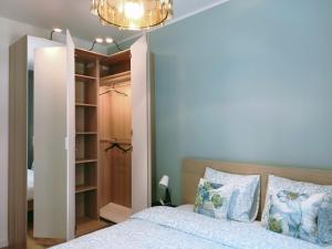 a bedroom with a bed and a chandelier at Gold Key komfortowy apartament z balkonem, klimatyzacja i parkingiem in Pruszków