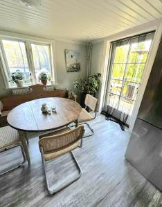 a living room with a table and chairs and windows at Roslagen sjötomt ,gårdshus på större gård in Grisslehamn
