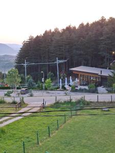 un estacionamiento con un edificio y un campo de césped en Zlatište, en Sarajevo