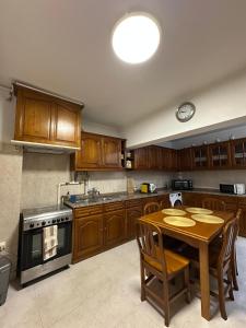 a kitchen with wooden cabinets and a table with chairs at Alvor Riverview in Alvor