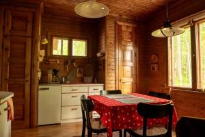 a kitchen with a table with a red table cloth at Scandinavian summer cottage in Asikkala in Asikkala