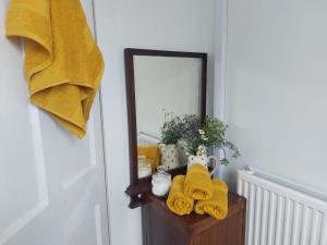 ein Badezimmer mit einem Spiegel und Handtüchern auf einem Tisch in der Unterkunft Skye Cottage - Vegan and Eco in Bernisdale