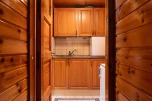 a kitchen with wooden cabinets and a sink at Scandinavian summer cottage in Asikkala in Asikkala +17 photos