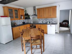 a kitchen with wooden cabinets and a wooden table and chairs at Nice detached stone house in Saint-Léger-sur-Dheune +6 photos