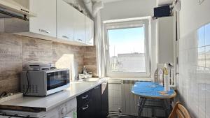 a kitchen with a counter with a microwave and a table at To the Nerversea beach! in Constanţa