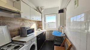 a kitchen with a washing machine and a microwave at To the Nerversea beach! in Constanţa +9 photos
