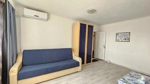 a living room with a blue couch in a room at To the Nerversea beach! in Constanţa