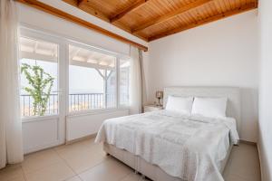 una camera da letto bianca con un letto e due finestre di Marmara Yali Evi a Isola di Marmara