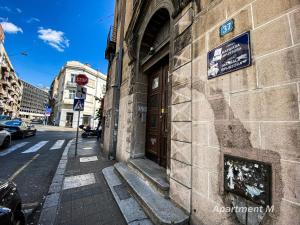 un edificio con una puerta al costado de una calle en Apartman M, en Belgrado