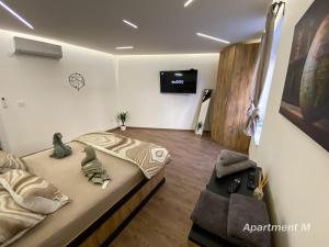 Una habitación con una cama y un televisor en la pared. en Apartman M, en Belgrado