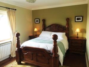 a bedroom with a wooden bed with two night stands at Wild Atlantic Breeze Guesthouse in Doolin