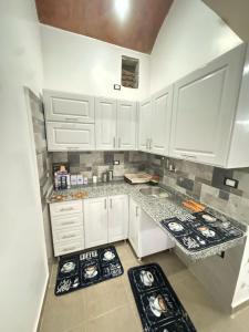 una cocina blanca con armarios y encimeras blancos en Salem & Renča Guest House, en Luxor