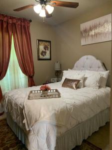 Un dormitorio con una cama blanca y una bandeja. en Bennu's Country Cottage near Nicholls State and local hospitals, en Thibodaux