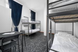 a dorm room with two bunk beds and a table at Wellness Hostel Central in Prague +48 photos