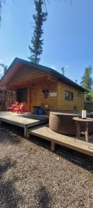 a log cabin with a table and a couch in front of it at Beautiful Cabin near Radium Hot Springs with private hot tub in Radium Hot Springs
