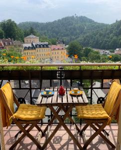 a table and chairs on a balcony with a view at RomanceArt Apartments in Karlovy Vary