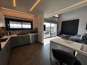 a kitchen with a table and a living room at The Artist House - Best Sea View in Porto Rafti in Porto Rafti