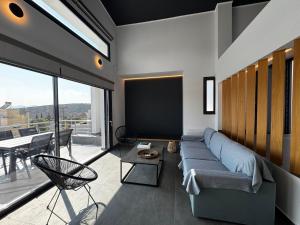 a living room with a couch and a large window at The Artist House - Best Sea View in Porto Rafti in Porto Rafti