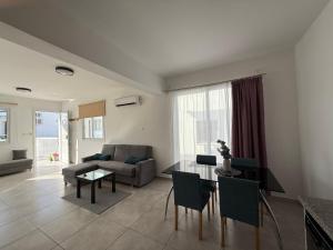 een woonkamer met een tafel en een bank bij Sun & Sea House in Paralimni