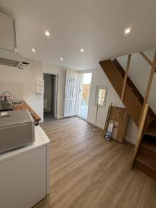 a living room with a kitchen and a staircase at Residence du bois 2 in Mitry-Mory