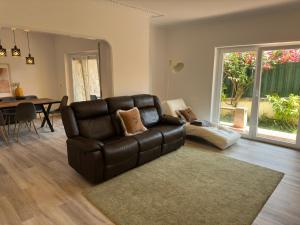 a living room with a leather couch and a table at Bay Golf House in Cascais