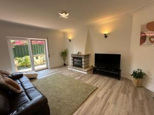 a living room with a couch and a flat screen tv at Bay Golf House in Cascais