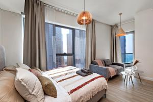 ein Schlafzimmer mit einem Bett und einem großen Fenster in der Unterkunft Stylish Urban Stay at Marina, Studio with All Essentials in Dubai