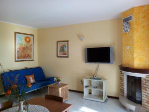 a living room with a blue couch and a tv at Mon Refuge Villa Deluxe in Correzzola