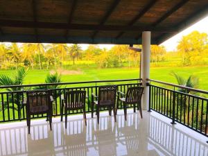 une terrasse couverte avec des chaises et une vue sur un parcours de golf dans l'établissement Peacock Kingdom, à Anurâdhapura